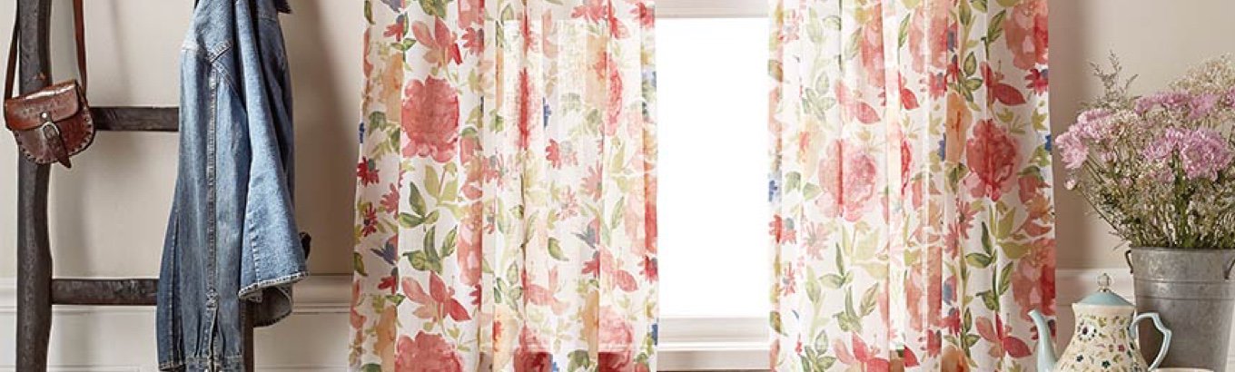 A set of floral curtains in a window. Starts the window treatment ideas blog post on dxdailystore.com.
