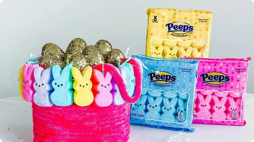 An Easter basket filled with golden eggs and multi-colored Peeps Marshmallow Chicks.