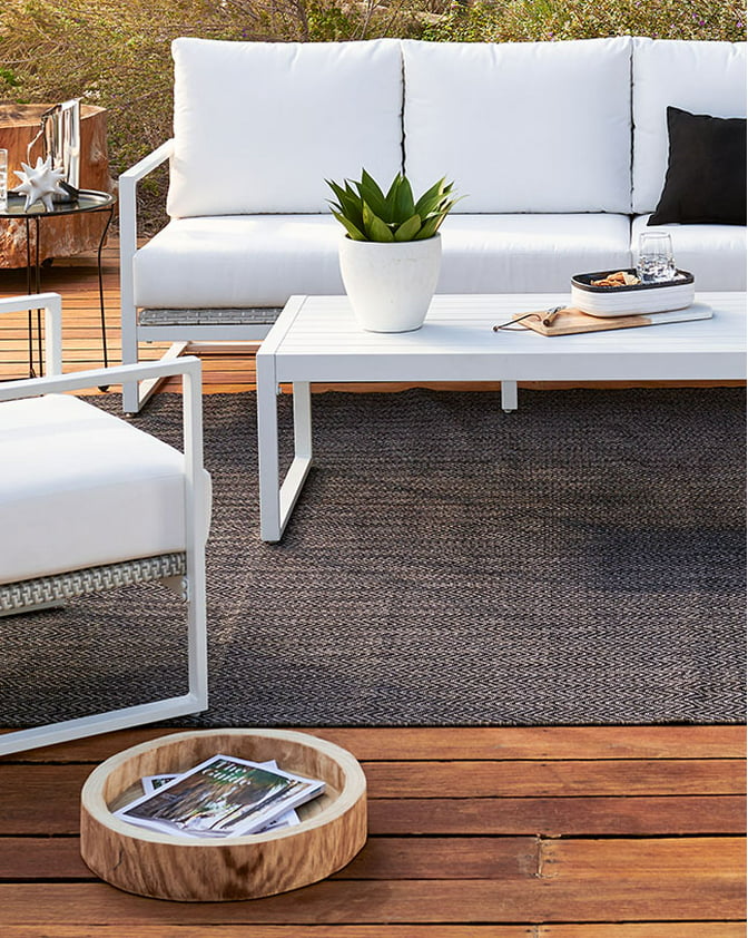 A modern white outdoor conversation set on a wooden patio. Links to patio furniture on dxdailystore.com.