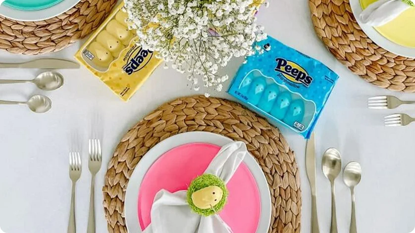 Peeps-shaped napkin decorations with Peeps Marshmallow Chicks next to silverware and dishes.