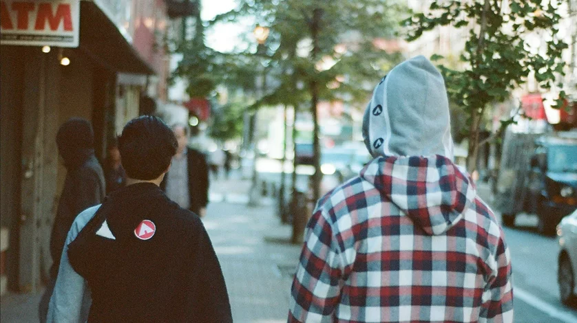 Two models walk down the street wearing Airwalk tees and hoodies.